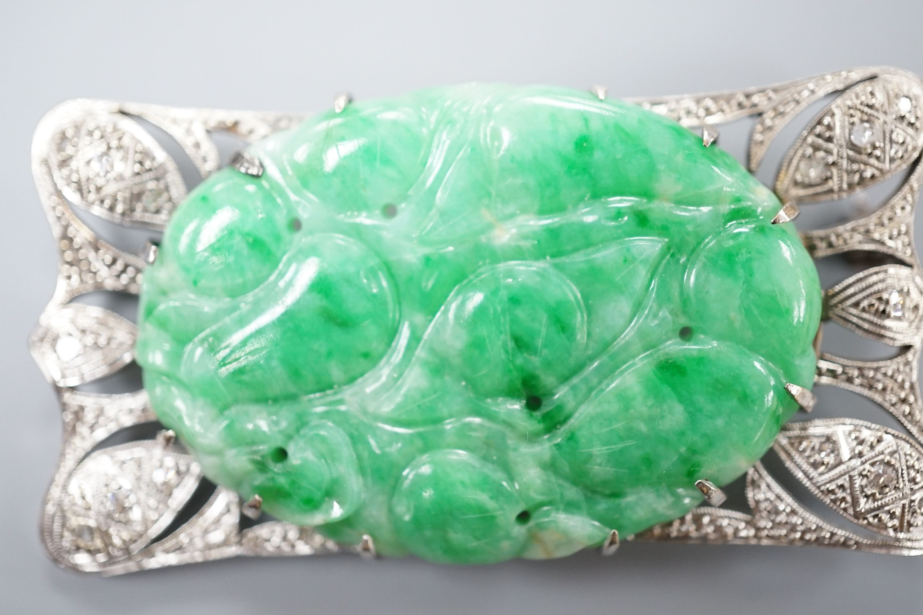 A white metal (stamped 9C?), diamond chips and oval carved jade set shaped rectangular brooch, 52mm, gross weight 13.1 grams.